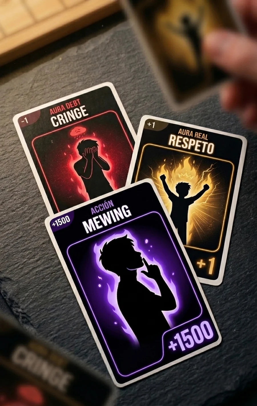 Tres cartas de Aura Farming sobre una mesa: Cringe, Respeto y Mewing